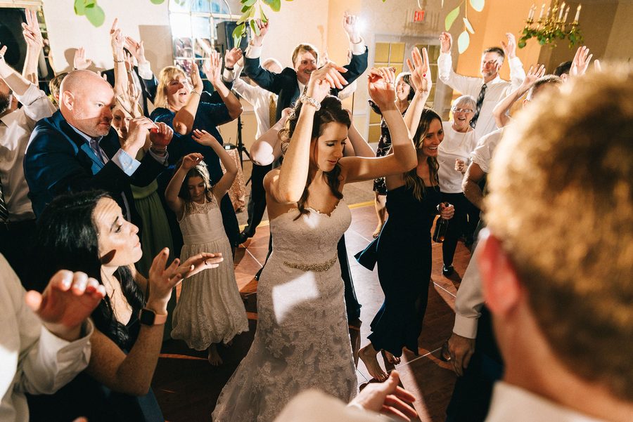 Bride dancing with wedding guests on a packed reception dancefloor